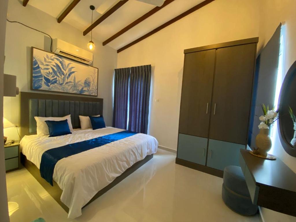 Un dormitorio con una cama grande y una cómoda. en Santorini Meraki Villas, en Negombo