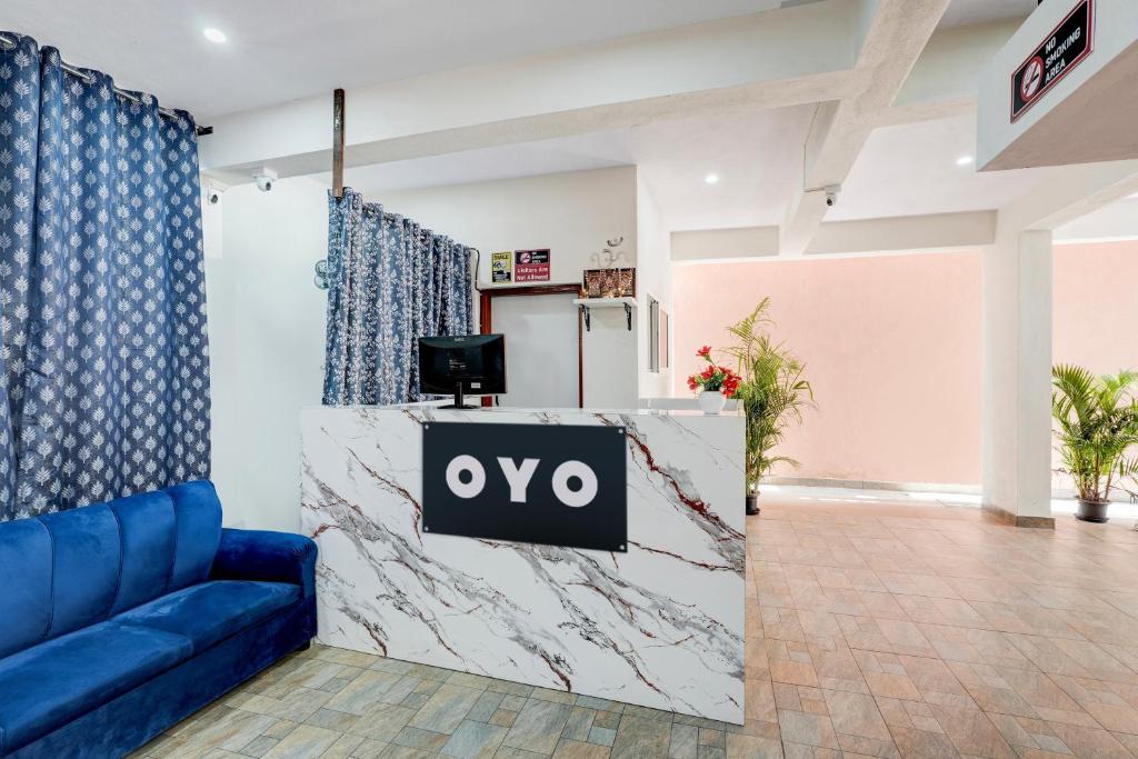 a lobby with a blue couch and a tv on a counter at Hotel O Nature Comforts in Bengaluru