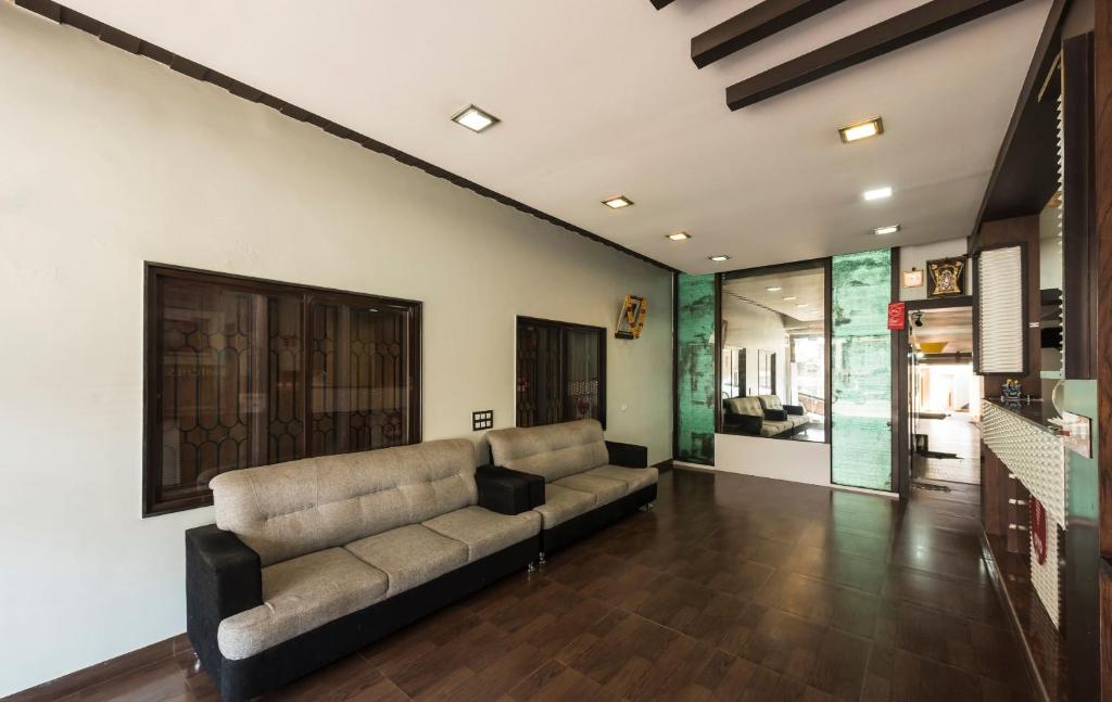 a living room with a couch in the middle at Super Hotel O Sai Kalyan Suites in Chikmagalūr
