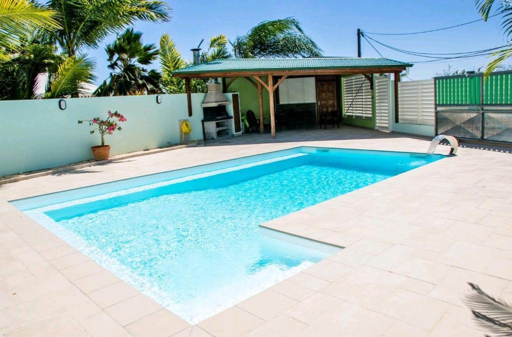 a swimming pool in a backyard with a gazebo at Les 3 Ti Fruits in Les Anses-dʼArlets