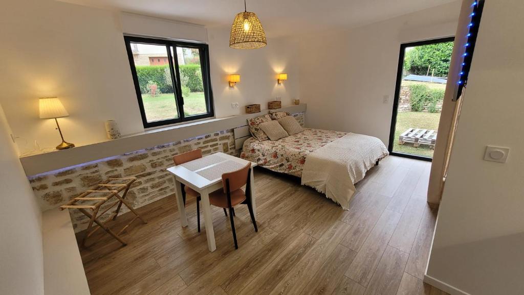 カオールにあるChambres d'hôtes - Studio La Pause Cadurcienneのベッドとテーブルと椅子のある寝室