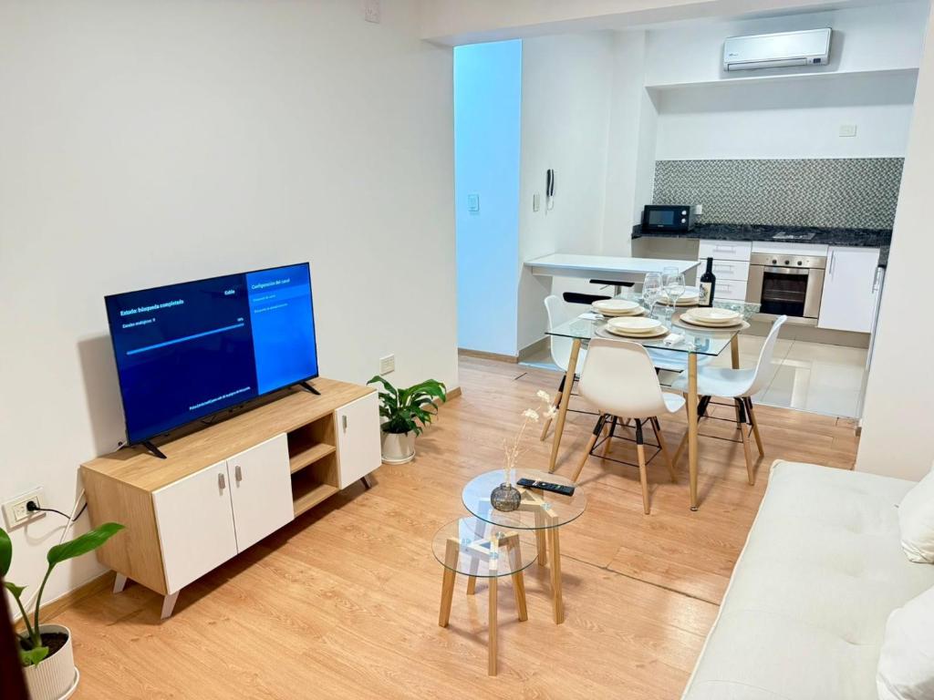 a living room with a tv and a table with chairs at Departamento Moderno y céntrico in Salta