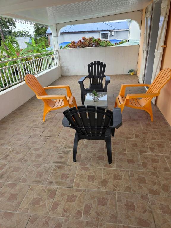 a patio with two chairs and a table on a balcony at Chez Josie et Julien in Sainte-Rose