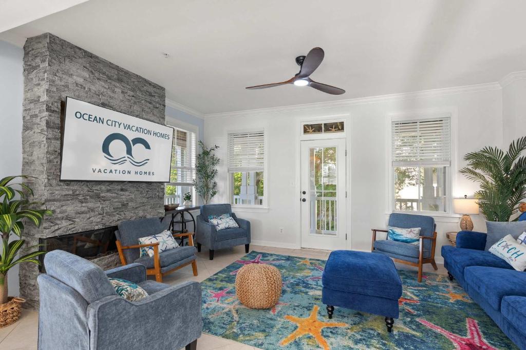 オーシャンシティにある27 Island Edge - Sunset Island Family Luxury Townhomeのリビングルーム(青い椅子、暖炉付)