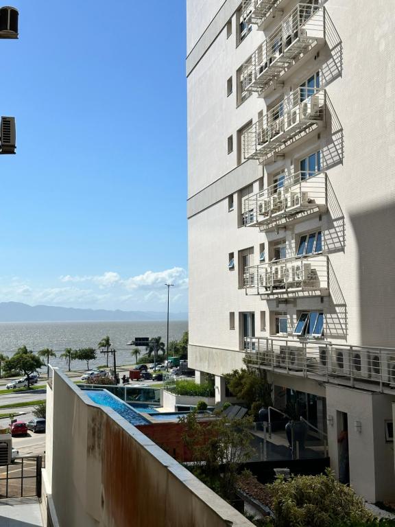 a building with balconies and a view of the ocean at Refúgio Sofisticado Beira Mar in Florianópolis