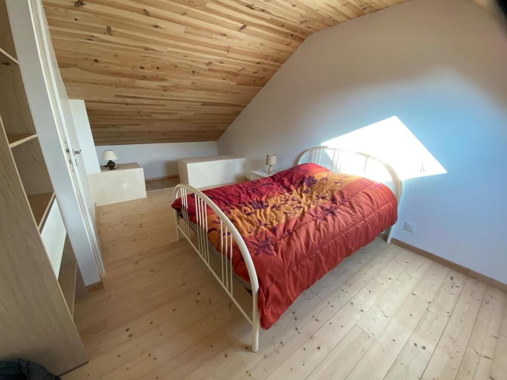 una camera da letto con un letto con una coperta rossa di Maison Yvonne 