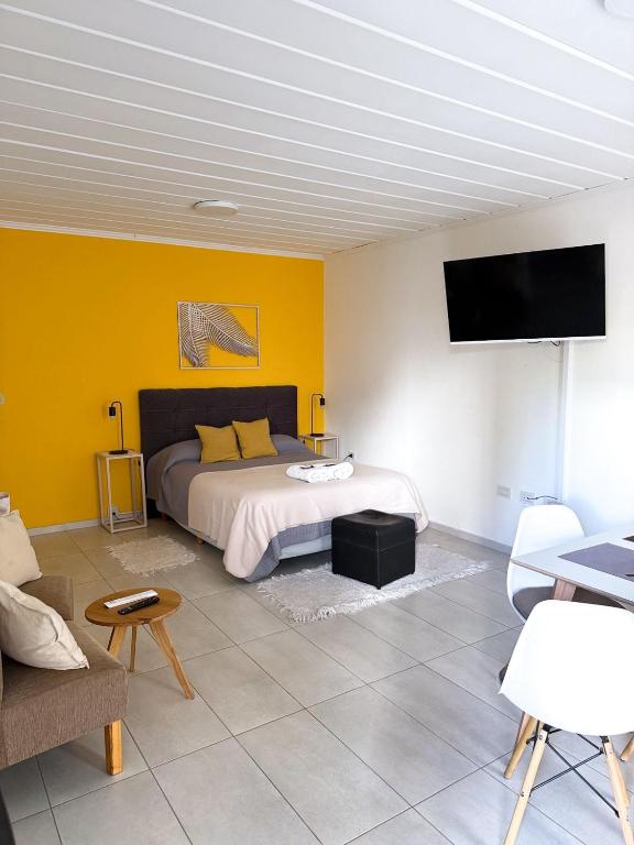 a bedroom with a bed and a yellow wall at Departamento El Olivo con cochera in Santa Rosa
