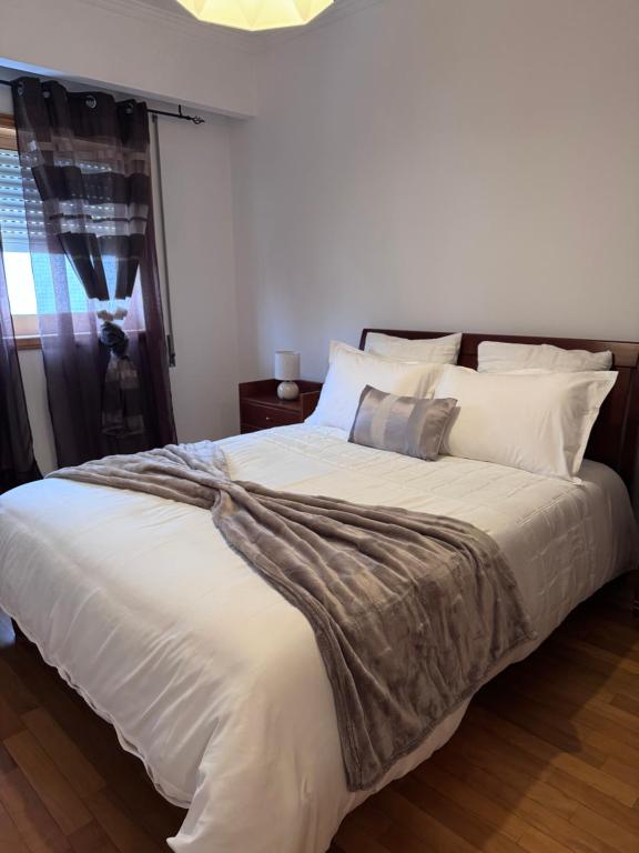a bedroom with a large bed with white sheets and pillows at Jose s place in Alfena