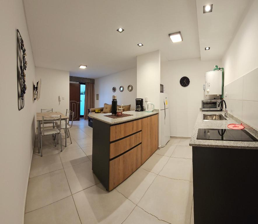 a large kitchen with a counter and a table at DG Rosa María in Santiago del Estero