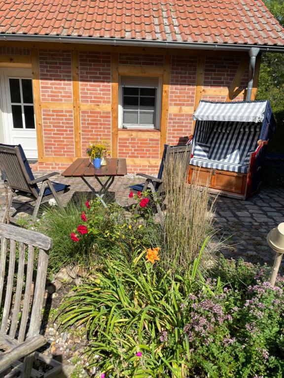 a garden with chairs and flowers in front of a house at Ferienwohnung am Netzener See in Lehnin