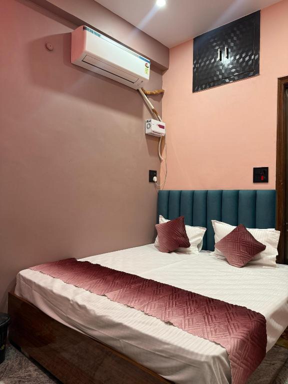 a room with two beds and a air conditioner at Om Sai Ram Home Stay in Varanasi