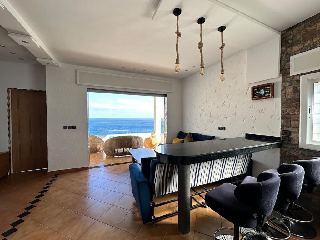 a living room with a piano and a living room with a view at Belyounech Panorama Sea and Mountain Apartment in Belyounech 