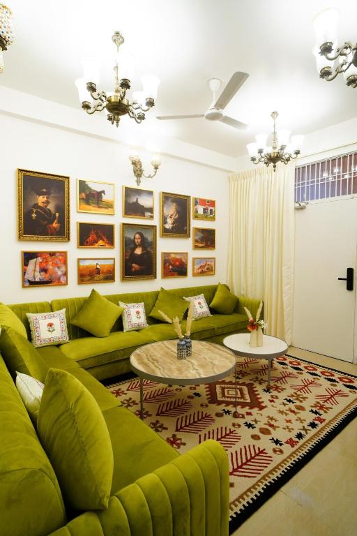 a living room with a green couch and a table at Met Luxe Galleria in Jaipur
