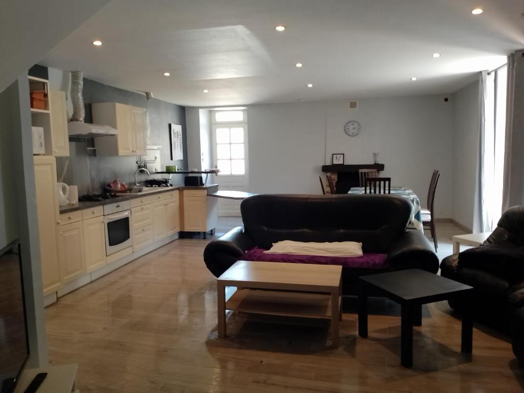 ein Wohnzimmer mit Sofa und eine Küche in der Unterkunft Duplex 100m2 in Montreuil-sur-Ille