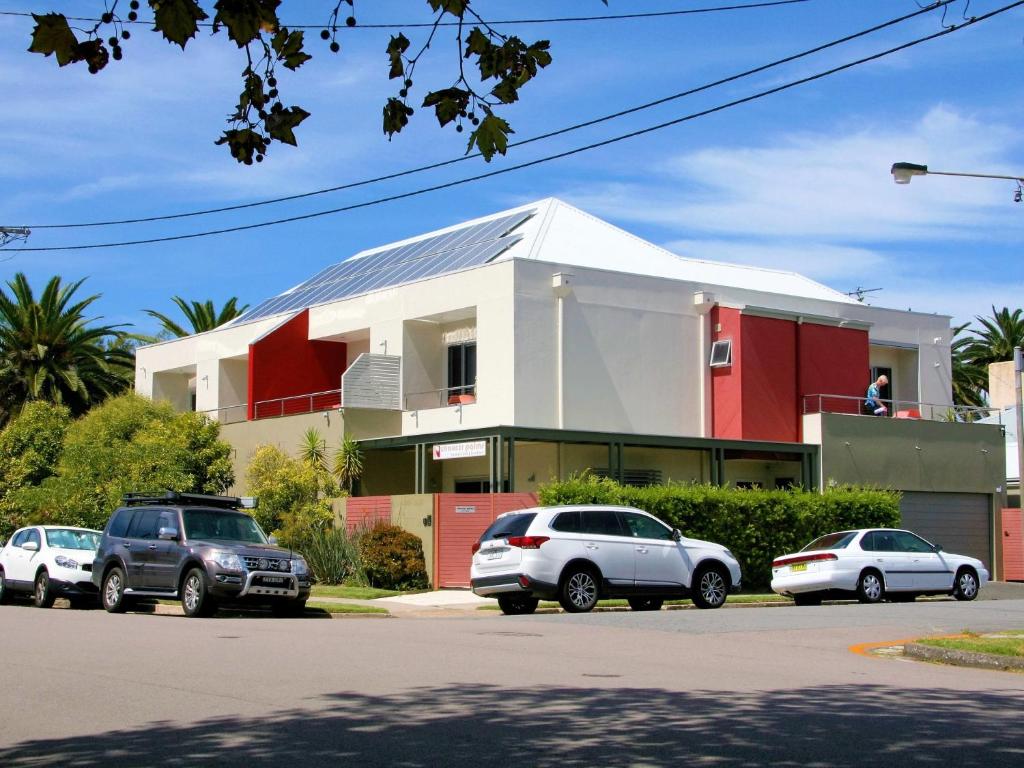a building with cars parked in a parking lot at Chaucer Palms Boutique B&B in Newcastle