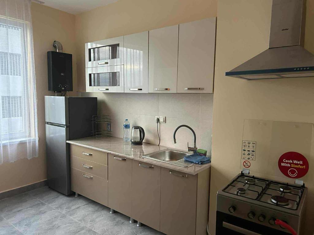 Una pequeña cocina con fregadero y refrigerador. en apartment, en Kutaisi