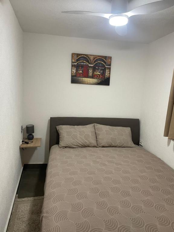 ein Schlafzimmer mit einem Bett mit einem Bild an der Wand in der Unterkunft Sutomore Panorama Apartment in Sutomore