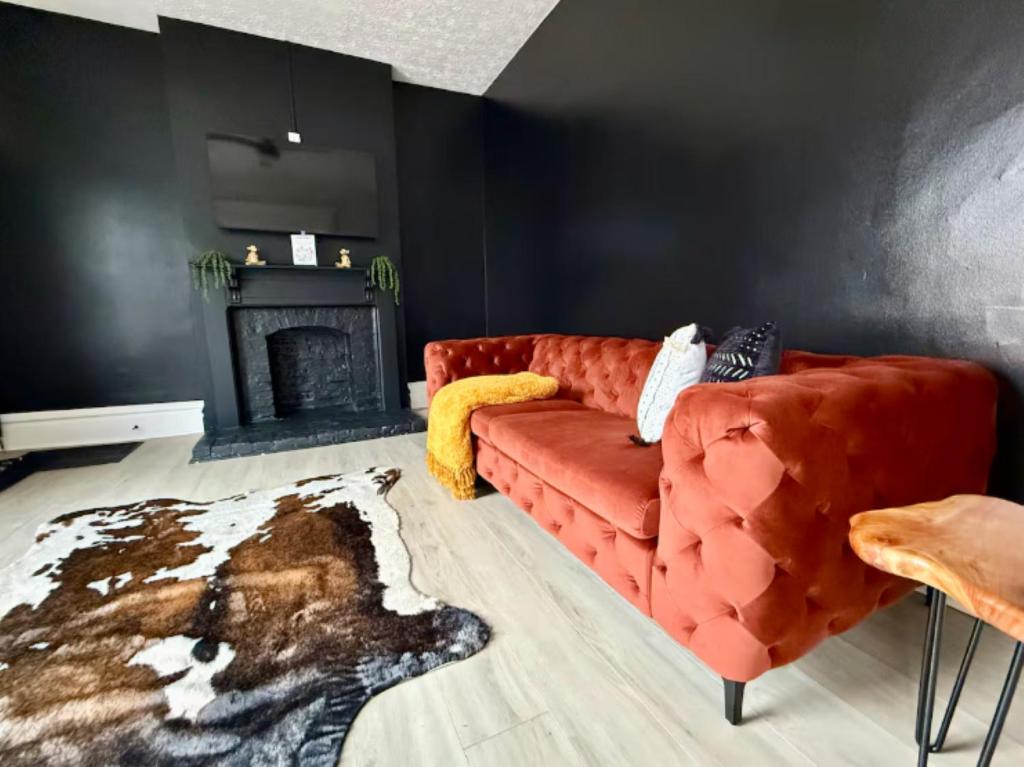 a living room with a red couch and a fireplace at Short North Convention King Bed Free Parking! in Columbus