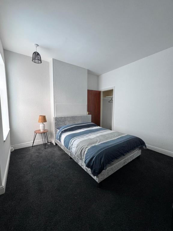 a bedroom with a bed and a lamp in it at Serenity Rooms in Leicester