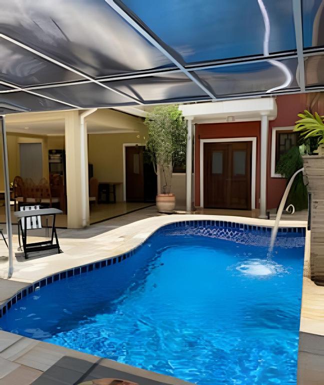 a swimming pool with a roof over it at Casa com piscina no Botânico in Ribeirão Preto