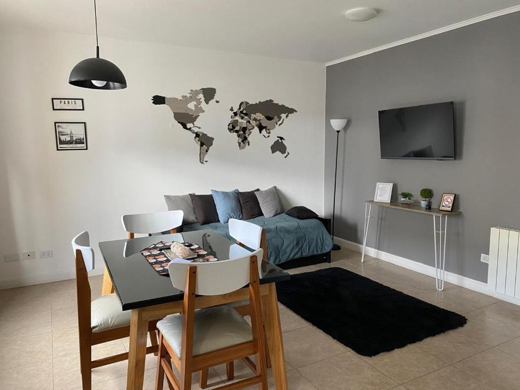 a living room with a table and a world map on the wall at Altos Patagonia in Río Gallegos