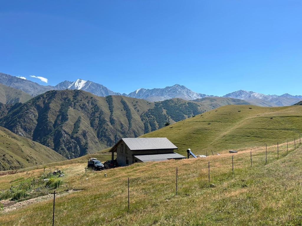 a barn on a hill with mountains in the background at Panorama Ardoti in Ardoti