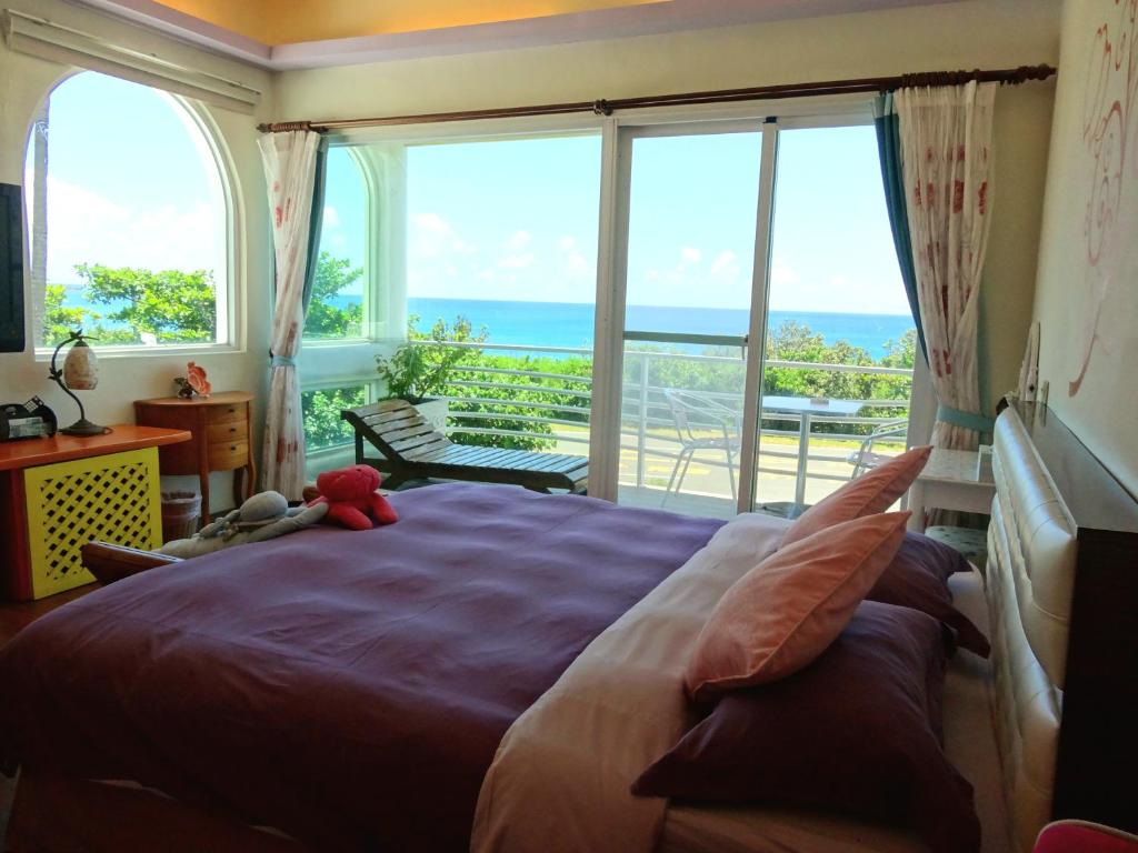 a bedroom with a large bed with a view of the ocean at 海洋玫瑰海景民宿 in Eluan
