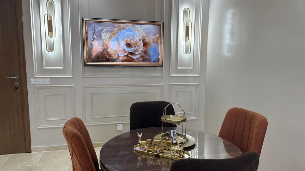 a dining room with a table and a painting on the wall at cozy appartement in Casablanca