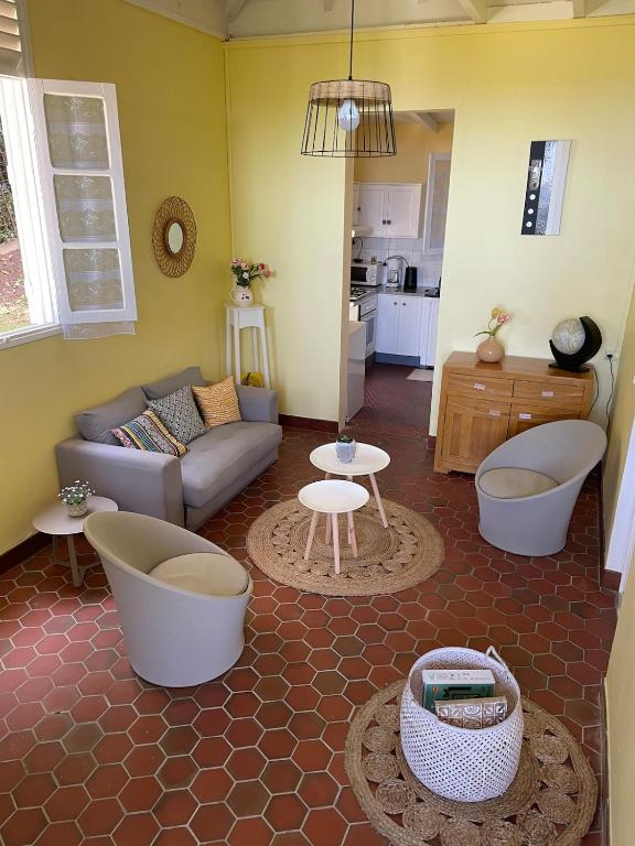 a living room with a couch and two tubs at Kafé House with breathtaking sea view in Deshaies