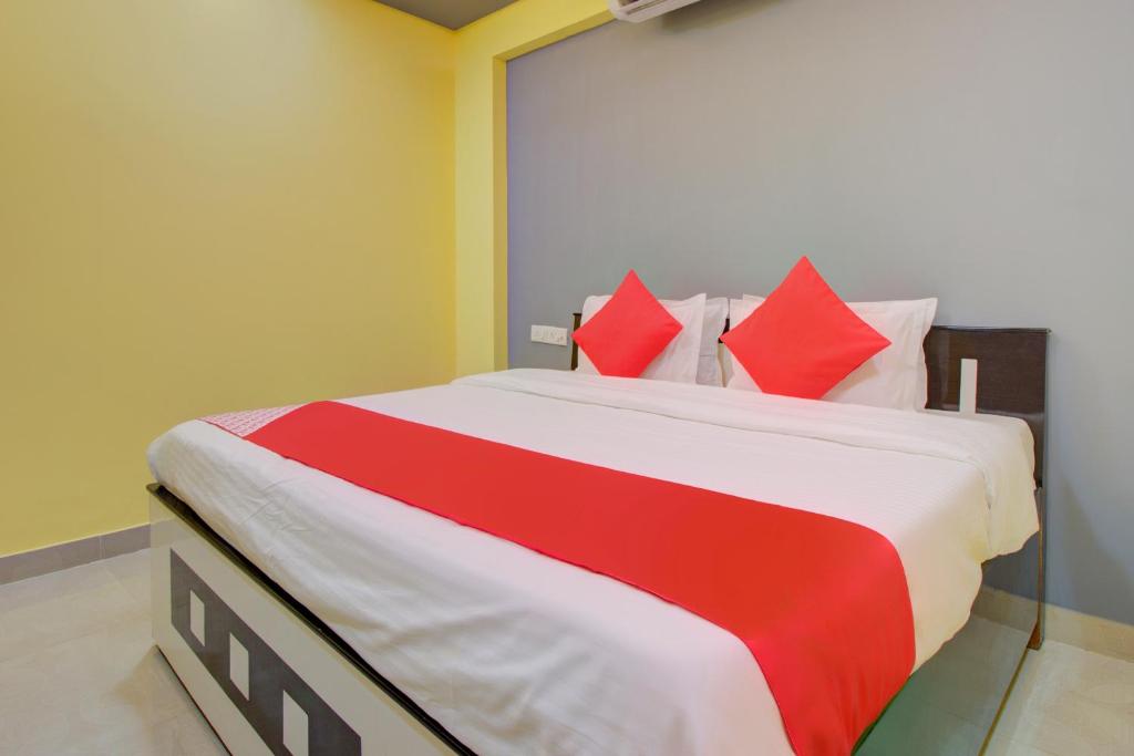 ein Schlafzimmer mit einem großen Bett mit roten Kissen in der Unterkunft Hotel O Tare Farms in Titwala