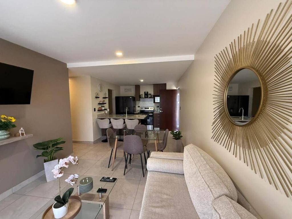 a living room with a couch and a mirror at Tropical Sunshine in Alajuela