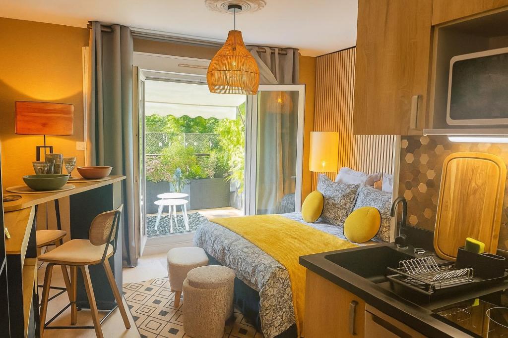 1 dormitorio con 1 cama y cocina con balcón en Petit Cocon des Rives Proche Stanislas, en Nancy