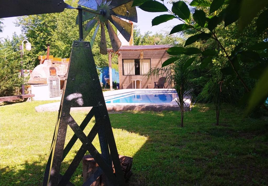 a wooden windmill in a yard next to a house at Casa Club Descanso in General Rodríguez