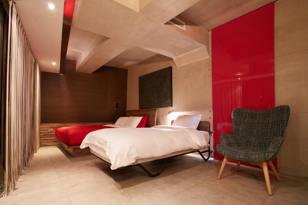 a bedroom with a large bed and a chair at Tria Business & Boutique Hotel in Seoul