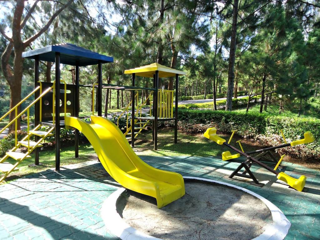 a playground with a yellow slide and a swing set at KTCH Holiday Home in Ulot