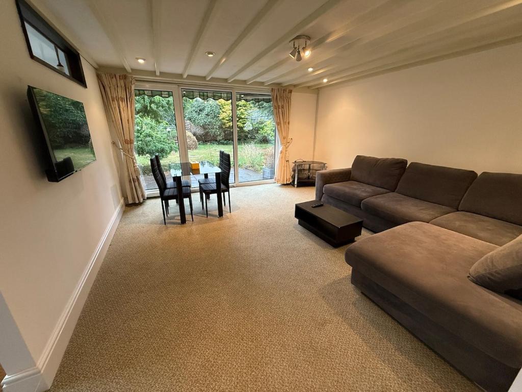 Bright & Cozy Countryside Bungalow في Tollerton: غرفة معيشة بها أريكة وطاولة