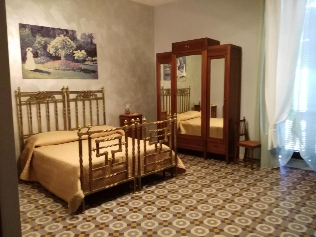 - une chambre avec 2 lits et un grand miroir dans l'établissement Domus Cicerone, à Formia
