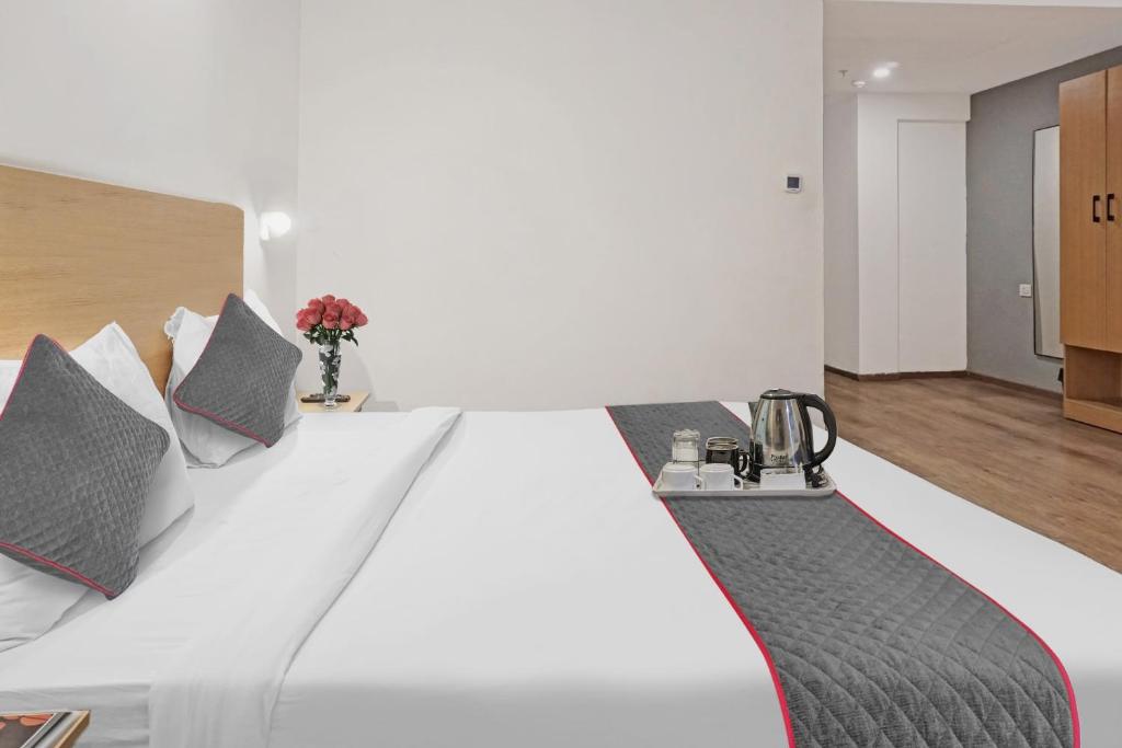 a bedroom with a large white bed with pillows at Townhouse Somani TC in Pune