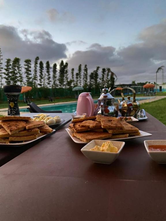 a table with plates of food on top at منتزه السلامة Parc ASSALAMA in Kenitra