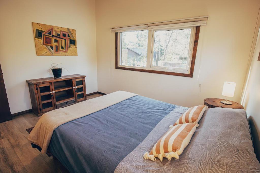 a bedroom with a large bed and a window at Pucon Villarrica Aldea Molco in Molco