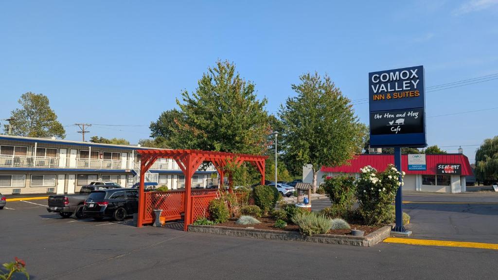 a parking lot with a sign in front of a building at Comox Valley Inn & Suites in Courtenay