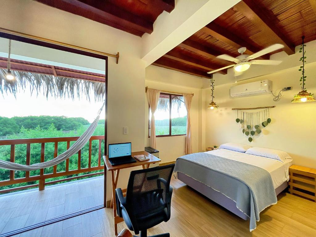 a bedroom with a bed and a desk with a laptop at Suite vista al mar I ABNB in Ayampe