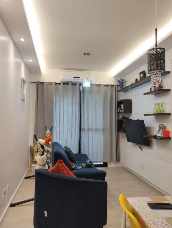 a living room with a blue couch and a table at APARTAMENTO COP30 - Natureza e bem estar juntos in Ananindeua
