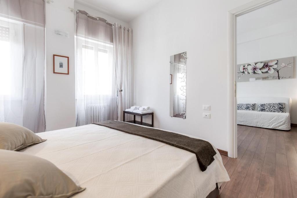 1 dormitorio blanco con 1 cama grande y espejo en San Jacopino - Flo Apartments, en Florencia