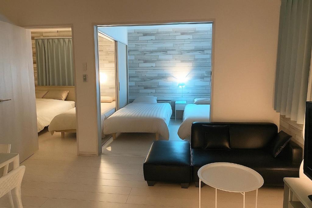 a living room with a couch and a bedroom at 優富良野 in Furano