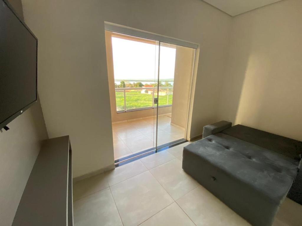 a room with a couch and a large window at Rancho do Rinoceronte - Miguelópolis in Miguelópolis