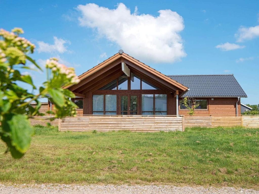 ein Zuhause mit einem Holzhaus auf einem Feld in der Unterkunft 6 person holiday home in Sydals-By Traum in Neder Lysabild