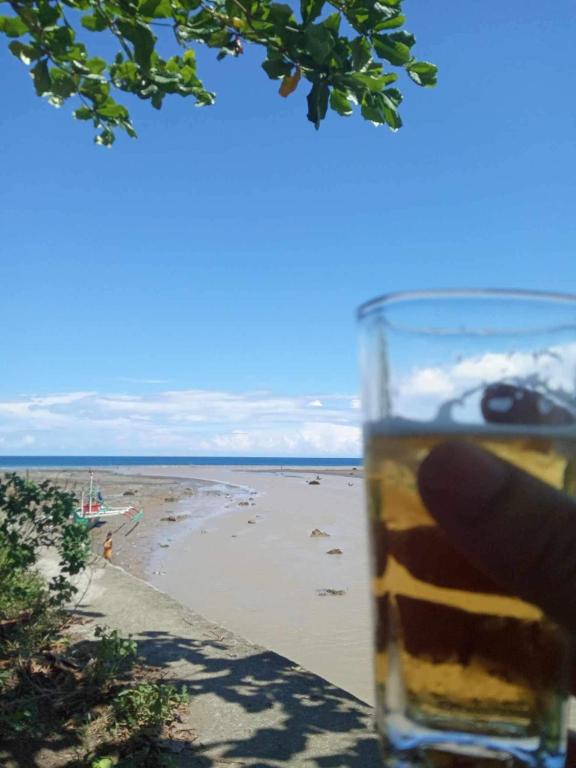a glass of beer in front of a beach at Casa Bambú in Pantukan