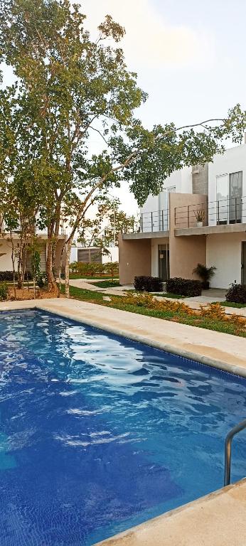 普拉亚卡门Casa de mama的建筑物前的一个大型蓝色游泳池