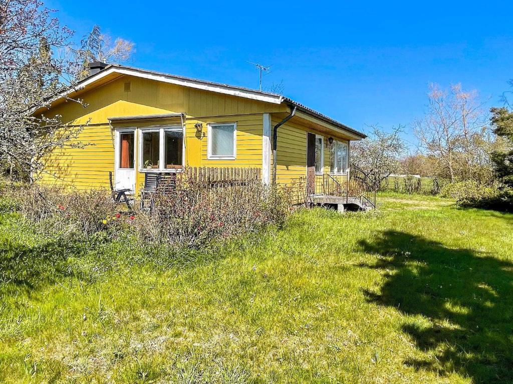 a yellow house in the middle of a field at Rural House with Garden Near Borgholm in Borgholm